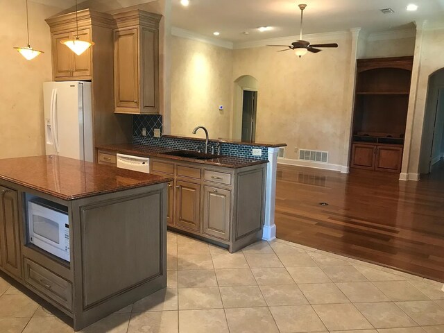 kitchen featuring white appliances, a center island, light hardwood / wood-style flooring, and sink