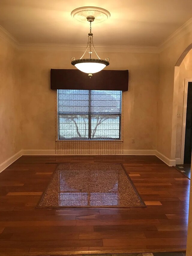 unfurnished dining area featuring dark hardwood / wood-style flooring and crown molding