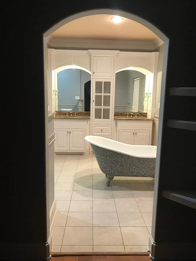 bathroom with sink, a bathtub, ornamental molding, and tile patterned flooring