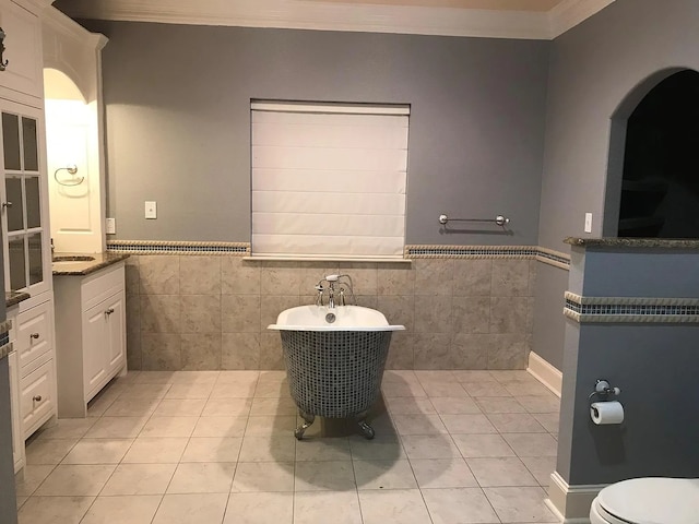 bathroom with tile patterned flooring, vanity, a bathtub, and tile walls