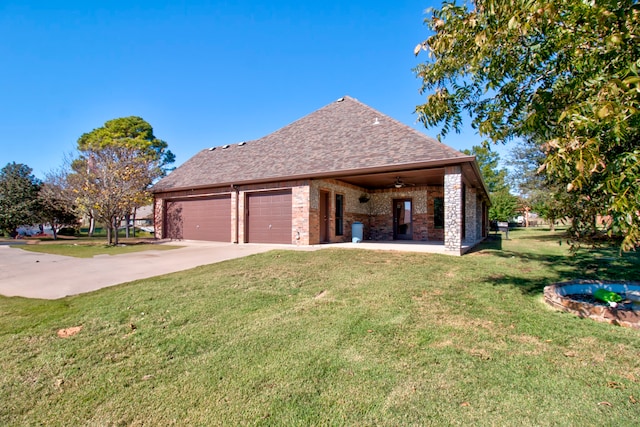 view of side of property with a lawn, ceiling fan, and a garage