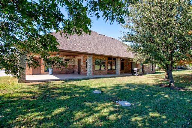 back of property with a lawn and a patio