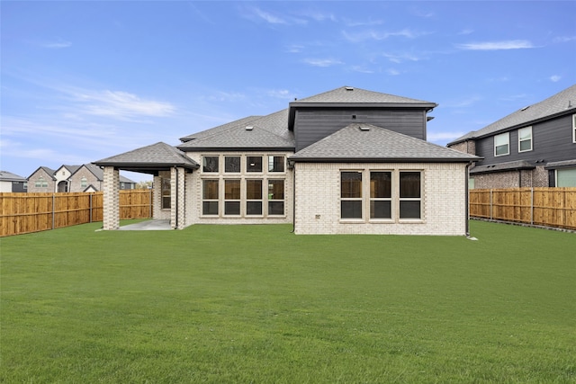 rear view of property featuring a lawn and a patio area