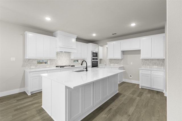 kitchen with a kitchen island with sink, sink, dark hardwood / wood-style floors, white cabinetry, and stainless steel appliances