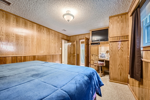 carpeted bedroom with wooden walls, crown molding, and a textured ceiling