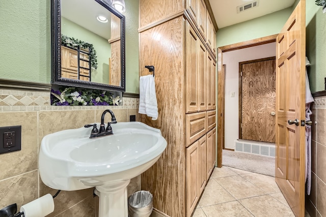 bathroom featuring tile patterned flooring and tile walls