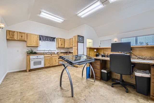 interior space featuring oven, built in desk, lofted ceiling, and light tile patterned floors