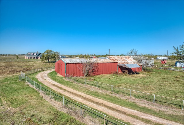 view of yard featuring a rural view and an outdoor structure