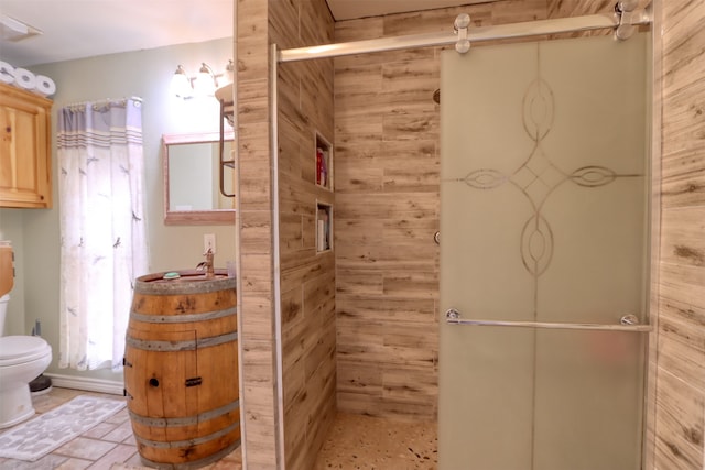 bathroom featuring vanity, toilet, walk in shower, and wood walls