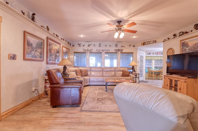 living room featuring ceiling fan, a wealth of natural light, and light hardwood / wood-style flooring