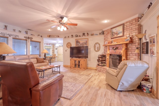 living room featuring ceiling fan, light wood-type flooring, and a brick fireplace