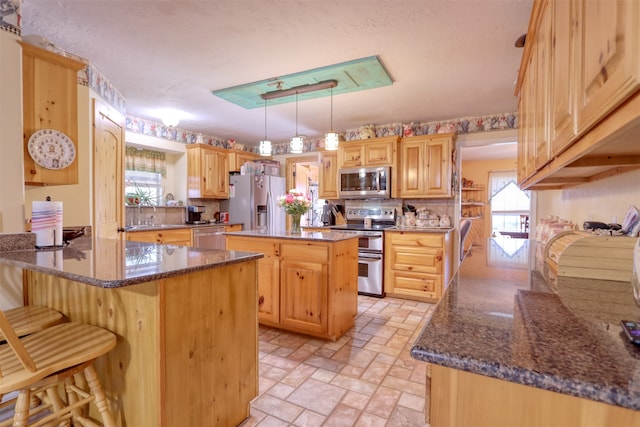 kitchen featuring plenty of natural light, a center island, stainless steel appliances, and hanging light fixtures