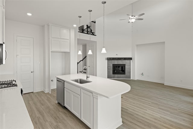 kitchen with white cabinetry, stainless steel appliances, sink, and a center island with sink