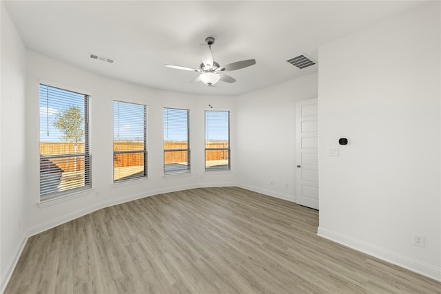 empty room with ceiling fan and light hardwood / wood-style flooring