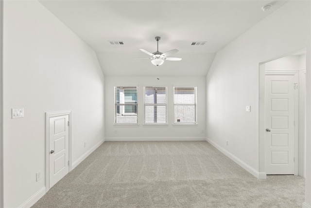 carpeted spare room featuring ceiling fan and lofted ceiling