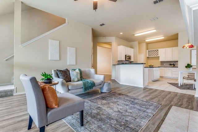 living room with ceiling fan and light wood-type flooring