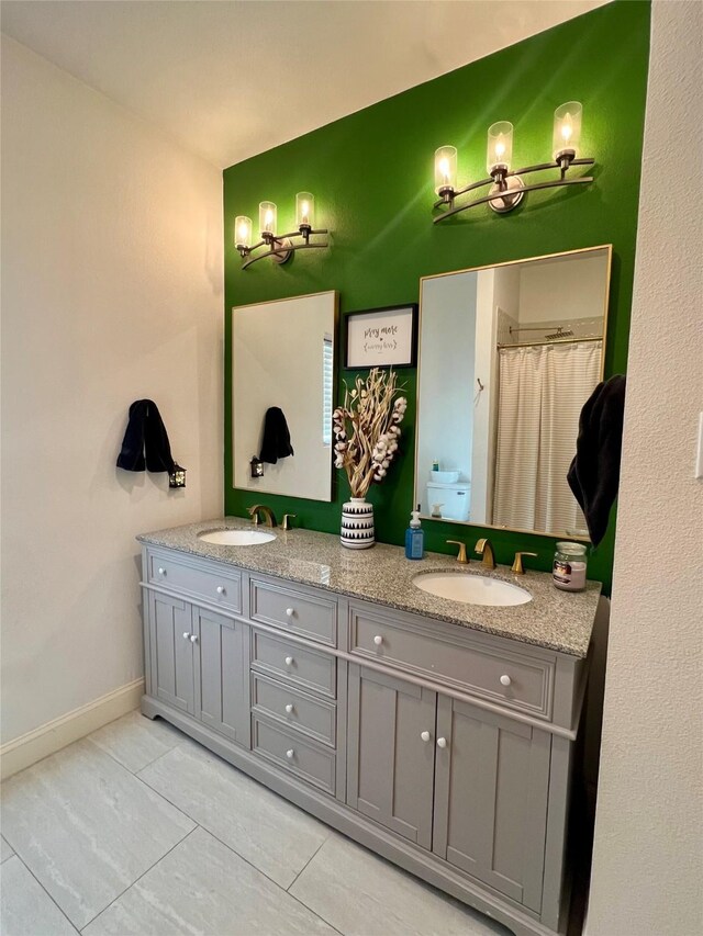 bathroom with a shower with shower curtain, tile patterned floors, vanity, and toilet