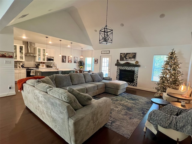 living room with plenty of natural light, dark hardwood / wood-style floors, and high vaulted ceiling