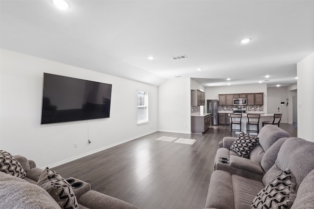 living room with dark hardwood / wood-style floors and vaulted ceiling