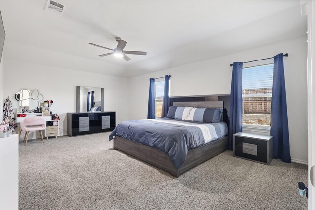 bedroom featuring multiple windows, ceiling fan, and carpet