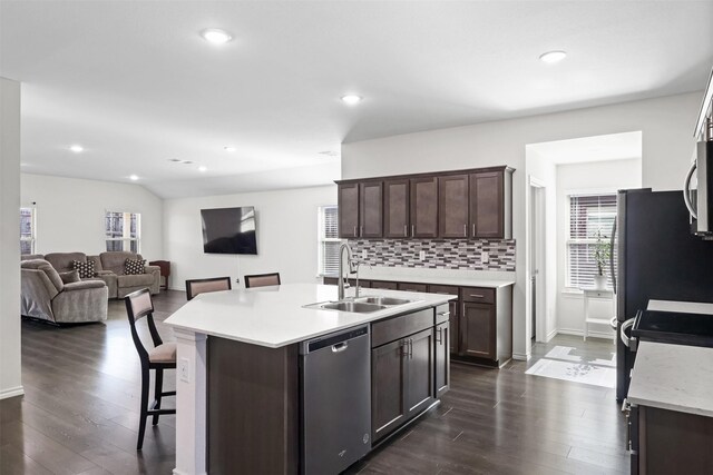 kitchen featuring sink, dark wood-type flooring, stainless steel appliances, a kitchen island with sink, and dark brown cabinets