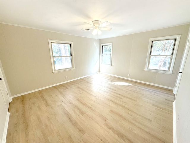 spare room with light hardwood / wood-style flooring, a wealth of natural light, ornamental molding, and ceiling fan