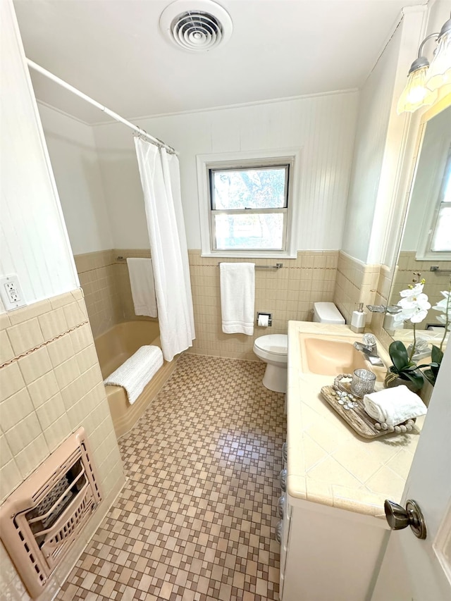 full bathroom featuring vanity, toilet, ornamental molding, tile walls, and shower / tub combo