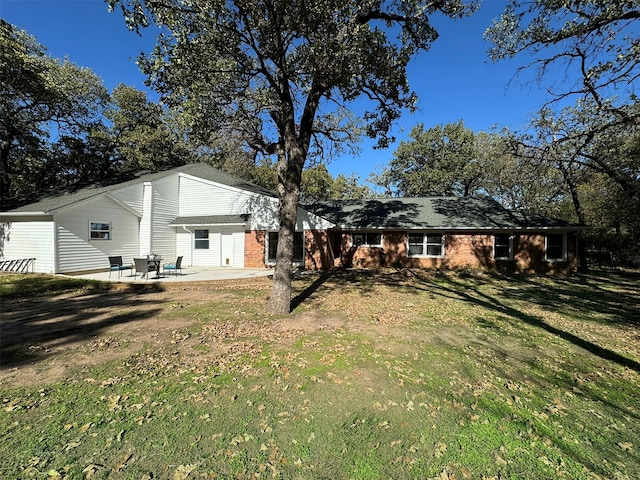 back of property featuring a lawn and a patio area