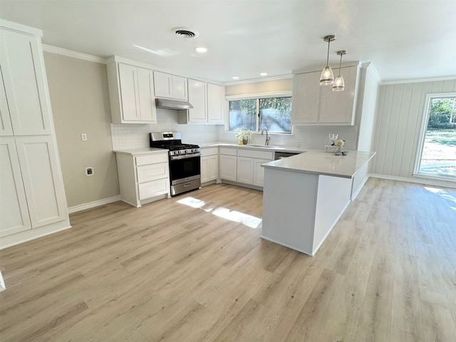 kitchen with pendant lighting, white cabinets, stainless steel gas stove, light hardwood / wood-style floors, and kitchen peninsula