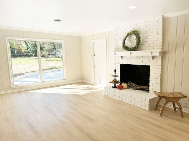 unfurnished living room featuring a fireplace, light wood-type flooring, and ornamental molding