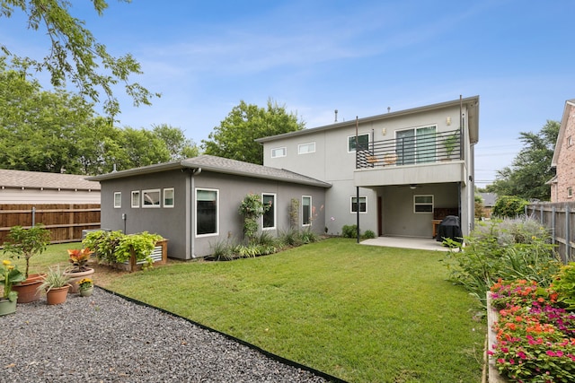 back of house with a lawn, a balcony, and a patio