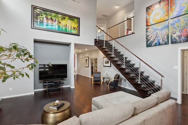 living room with a high ceiling and dark hardwood / wood-style floors