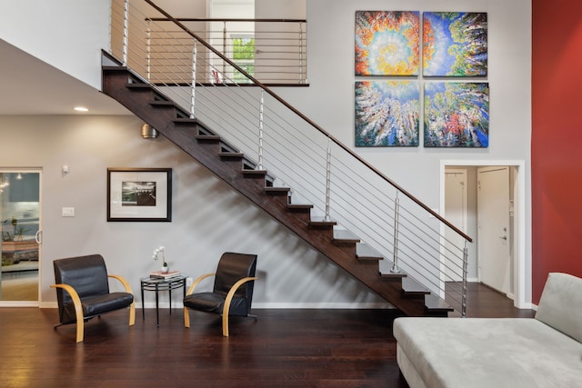 stairs featuring hardwood / wood-style floors and a high ceiling