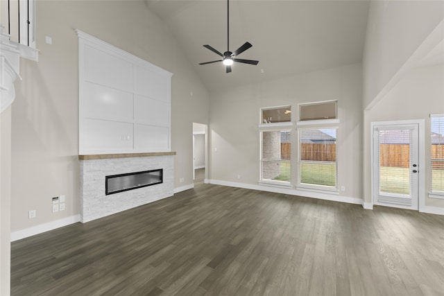 unfurnished living room with ceiling fan, a fireplace, high vaulted ceiling, and dark wood-type flooring