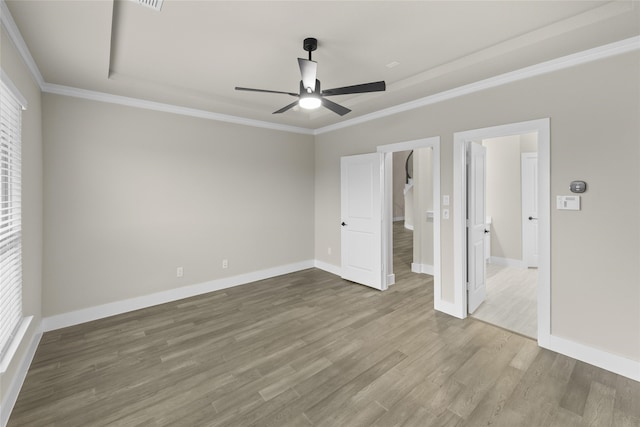 unfurnished bedroom featuring ceiling fan, crown molding, and wood-type flooring