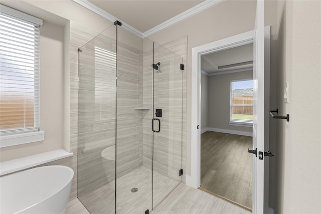 bathroom with hardwood / wood-style flooring, separate shower and tub, and crown molding