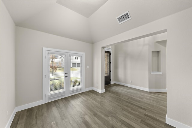 unfurnished room with french doors, dark wood-type flooring, and vaulted ceiling