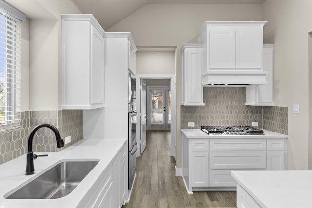 kitchen with backsplash, sink, white cabinets, and appliances with stainless steel finishes