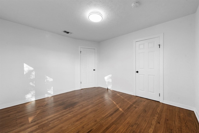 spare room with a textured ceiling and hardwood / wood-style flooring