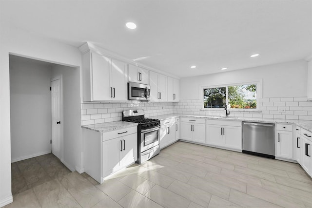 4536 Hodgkins Rd, Lake Worth, TX 76135 - kitchen featuring appliances with stainless steel finishes, a sink, light stone countertops, backsplash, and white cabinetry