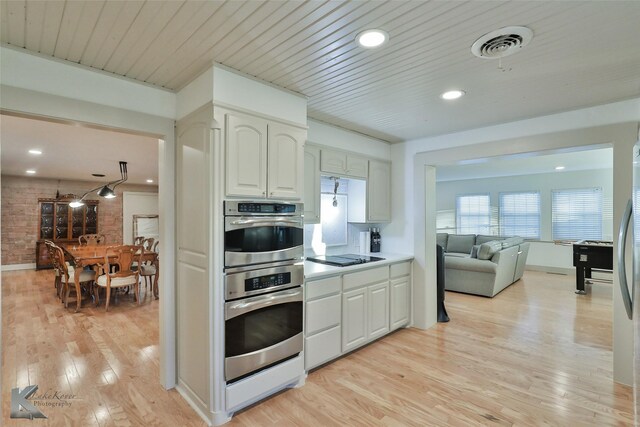 kitchen featuring white cabinets, light wood-type flooring, double oven, and wood ceiling