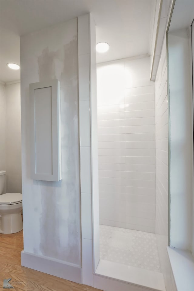 bathroom featuring hardwood / wood-style flooring, toilet, and walk in shower