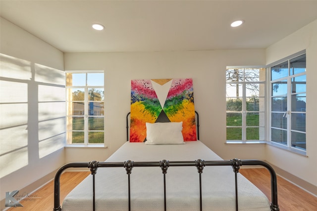 bedroom with multiple windows and hardwood / wood-style floors