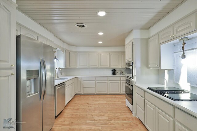 kitchen featuring white cabinetry, sink, light hardwood / wood-style floors, and appliances with stainless steel finishes