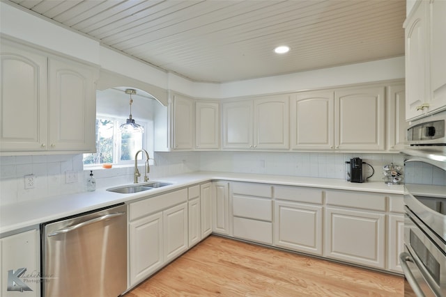 kitchen with dishwasher, decorative backsplash, decorative light fixtures, and light hardwood / wood-style flooring