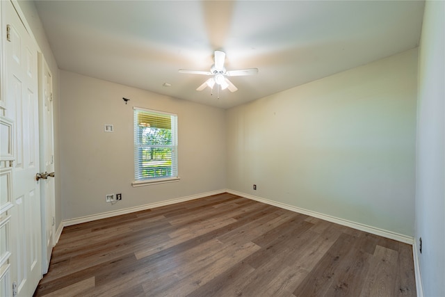 unfurnished room with ceiling fan and dark wood-type flooring