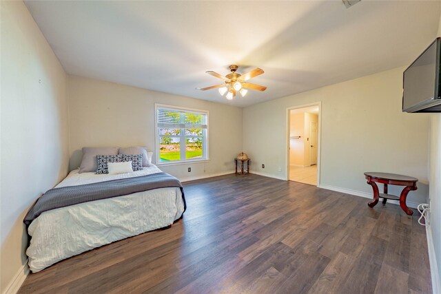 bedroom featuring dark hardwood / wood-style flooring, ceiling fan, and connected bathroom