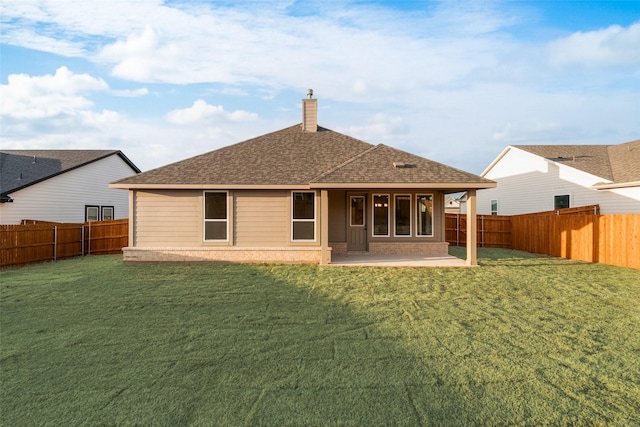 rear view of house featuring a fenced backyard, a chimney, a yard, a patio area, and brick siding