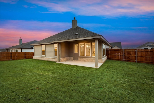 rear view of house with a patio area, a fenced backyard, a chimney, and a lawn