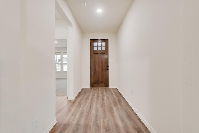 entryway with baseboards and light wood finished floors